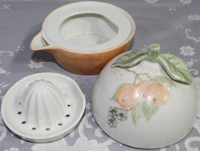 3 parts of oranges on orange & white ceramic juicer