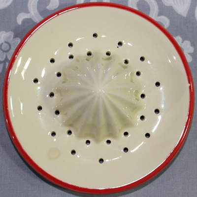 The reamer for a pink and red flowers on a white 2 piece juicer