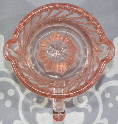 Top view of a spiralled pattern pink glass juicer