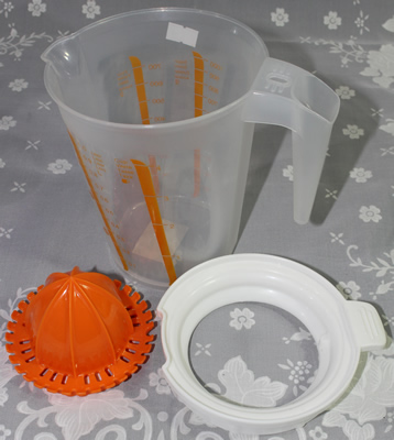 The 3 parts of an orange, white and clear plastic jug juicer