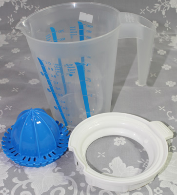 The 3 parts of an blue, white and clear plastic jug juicer