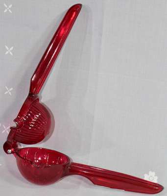 An open Quality & Classic hinged red plastic hand held squeezer 