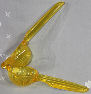 An open Quality & Classic hinged yellow plastic hand held squeezer 