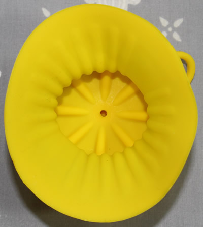 The bottom view of a yellow silicone lemon sleeve juicer