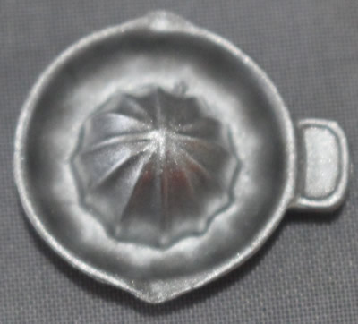Top view of a miniature plastic juicer with offset tab handle