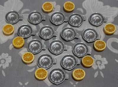 A group of miniature plastic juicers with offset tab handles 