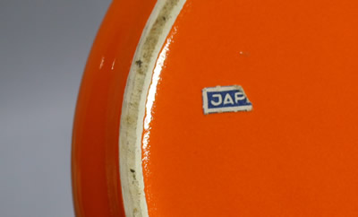 A partial label on an orange Japanese ceramic 2 piece juicer