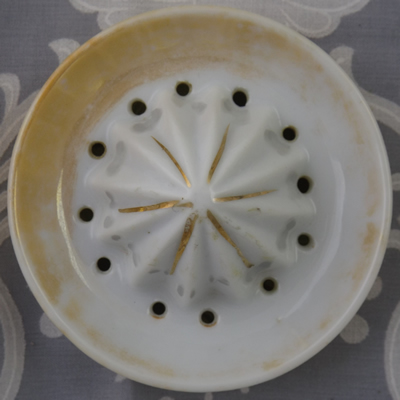 The reamer for a tan lustre ware juicer decorated with a lemon and leaves