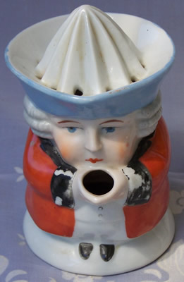 Front view of an orange with blue hat black collar1 piece toby juicer