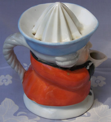 Right  view of an orange with blue hat black collar1 piece toby juicer