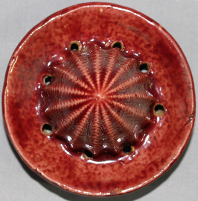 Reamer for yellow flowers on maroon ceramic juicer