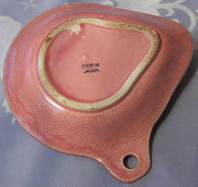 Base of a pink with multicoloured flowers hanging strainer juice