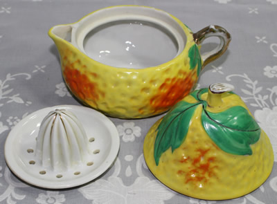 The 3 parts of a green leaves on yellow and orange pear shape juicer