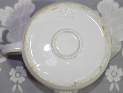 Impressed base of a white ceramic juicer showing grip on reamer