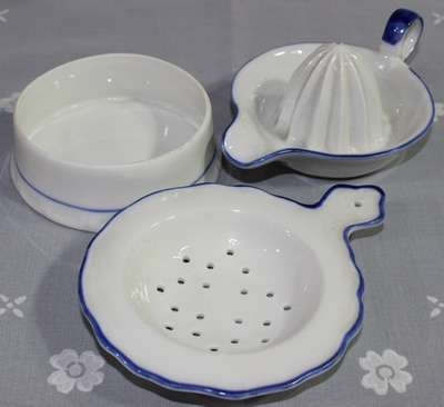 Complete set including strainer and bowl for awhite ceramic with blue trim loop handle juicer