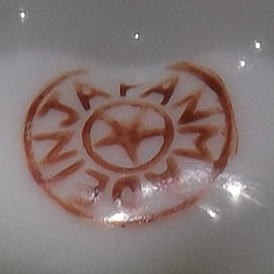 Orange, green and black on white saucer juicer base mark