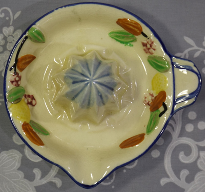 Mixed fruit on white saucer juicer with blue trim top view