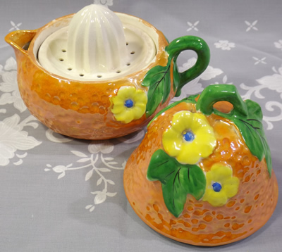 An open orange with yellow flowers 3 piece pear shape juicer