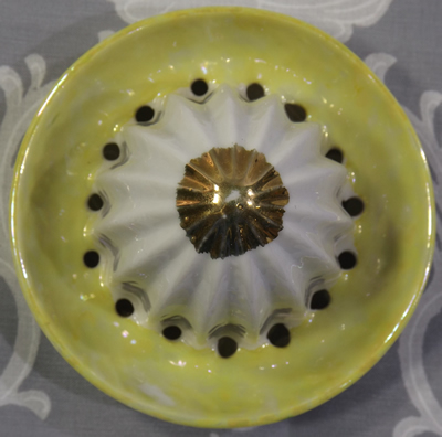 The reamer for a white flowers and green leaves on a lustre yellow green juicer
