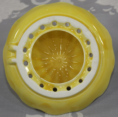 Bottom of the reamer of a dark cream yellow Carlton Ware juicer top showing the two positioning notches