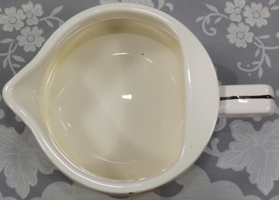 Apple on white jug with brown and red reamer jug top view