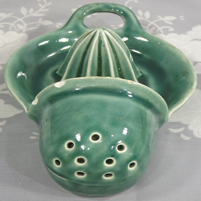 Front view of a large green hanging strainer juicer
