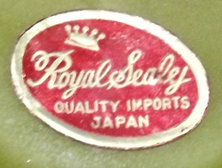 Royal Sealy label on a pineapples on an olive green pitcher with green fruit juicer 