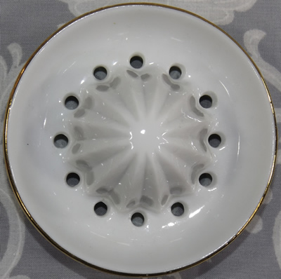 Reamer for insects and strawberries on a white ceramic juicer