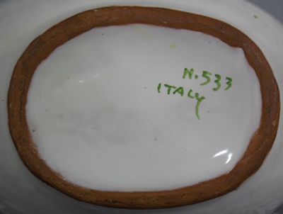 Base of a gravy boat shape juicer with green and yellow lemon slice 