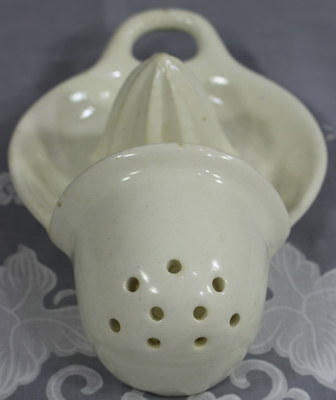 Front view of a white ceramic hanging 9 hole strainer juicer