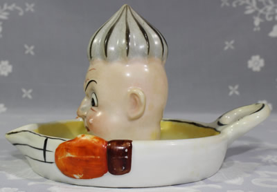 Side view of a Goebel frowning face clown saucer juicer