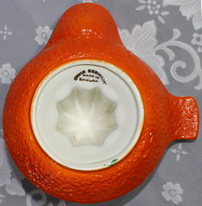 Bottom view of a John Beswick white on orange 'peel' texture saucer shape juicer
