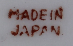 Red basemark on a yellow 'peel' with white and green ceramic juicer 