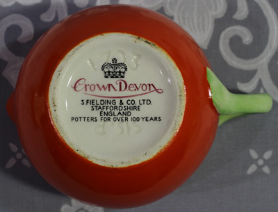 Base of a Crown Devon orange and white with green handle 2 piece juicer