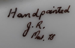 The signature on a hand painted yellow fruit juicer