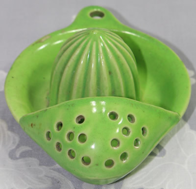 The front view of a green 16 hole Japanese strainer juicer