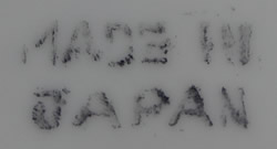 The basemark on a blue pattern on a white ceramic juicer