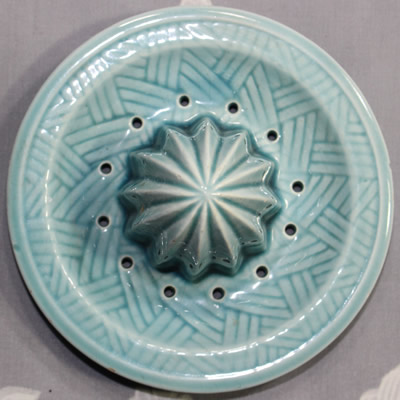 The reamer for the lemons on a blue ceramic jug juicer