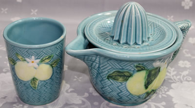 The lemons on a blue ceramic jug juicer and tumbler