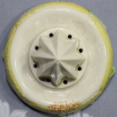 The reamer for an oranges on yellow, green leaves and tan handle juicer