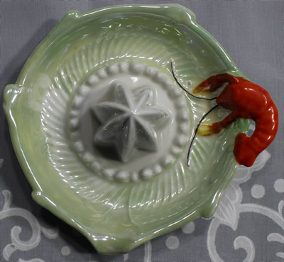 Top view of a red lobster on green lustre and white saucer shape juicer