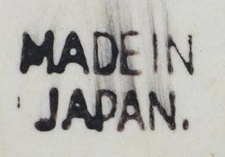 The basemark on a primitive image in brown on a beige ceramic juicer 