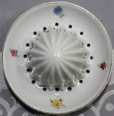 The reamer 4 different flowers on a white ceramic offset handle juicer