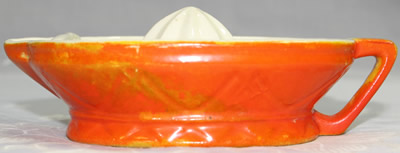The side view of an orange and white juicer with strainer wall