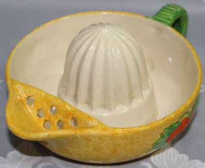 The strainer on a red fruit with green leaves on 1 piece sponged yellow juicer