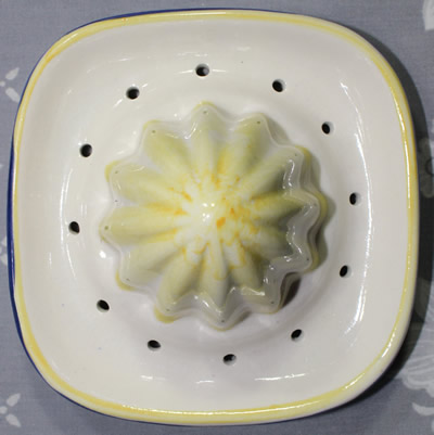 The reamer for a lemons and leaves on a blue ceramic juicer 