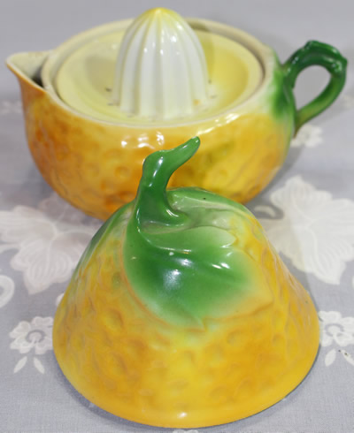 An open green leaves on orange on yellow lustre pear shape juicer