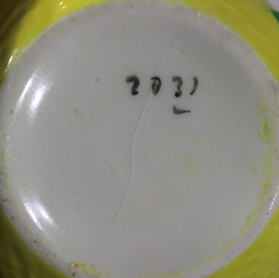 Signed "2032" on a yellow orange peel texture with white reamer juicer