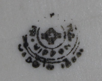 The basemark on a hand painted green leaves on an orange pear shape juicer