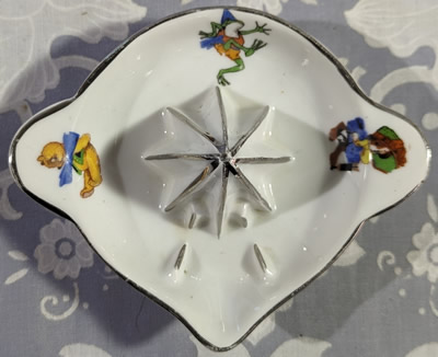 Top view of a 1 piece saucer shape juicer decorated with 3 children's characters
